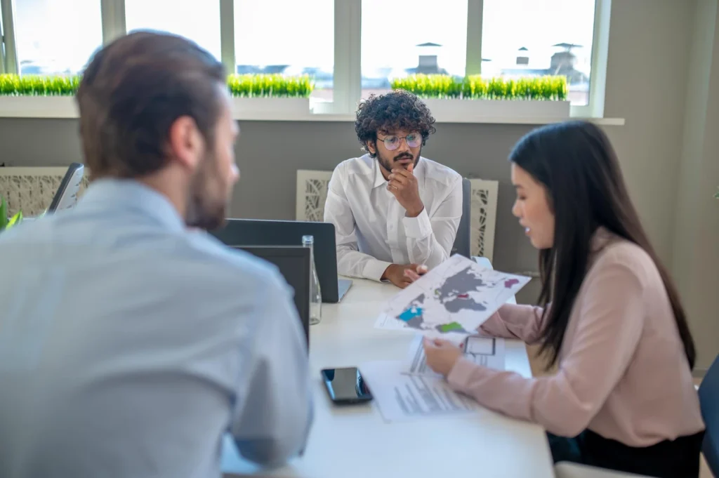 Business team. Two men and woman working in the office and looking involved